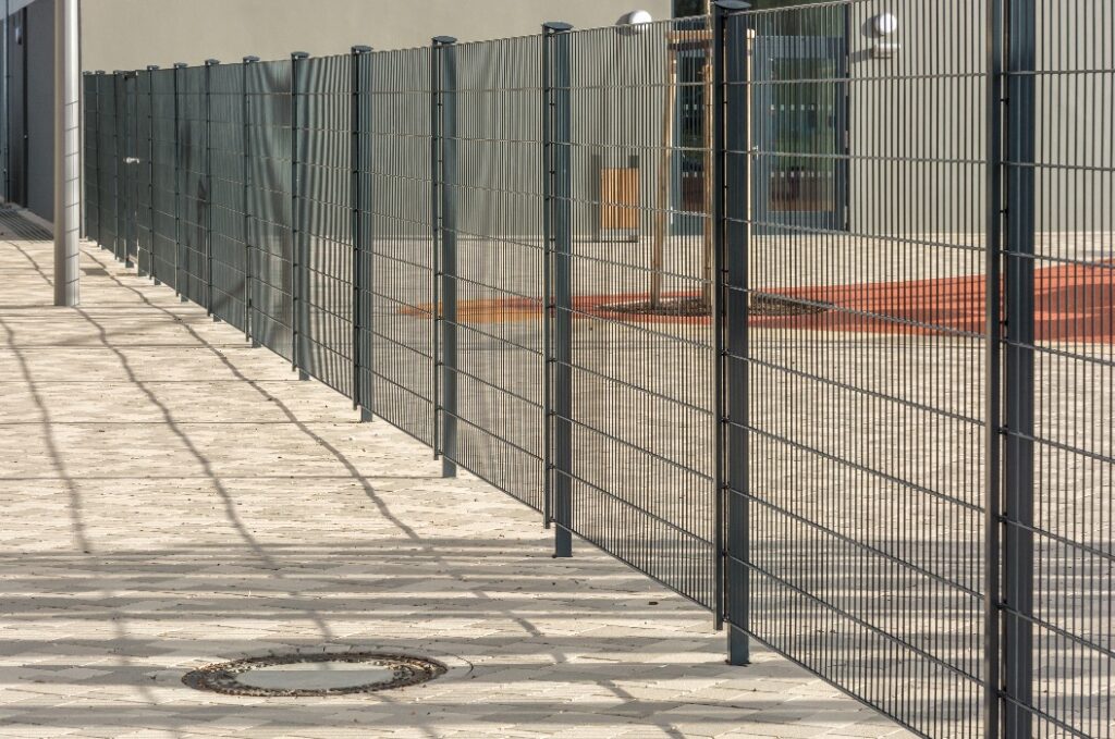 Moderner Metallzaun aus Doppelstabmatten zur sicheren Einzäunung eines Paussenhofs einer Schule